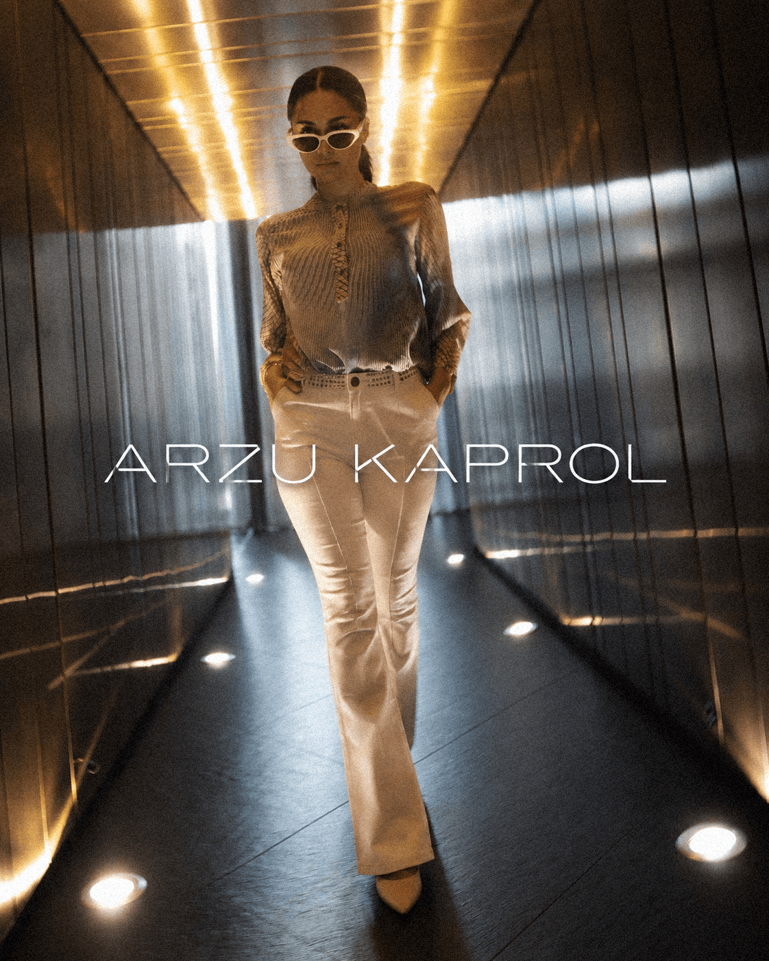 Arzu Kaprol katalog kapağı; ışıklı koridorda mimari çizgili bir tasarım